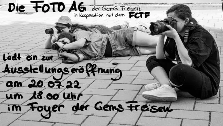 Schwarz-Weiß-Einladung der Foto-AG: Jugendliche fotografieren liegend und sitzend auf einem Pflasterplatz