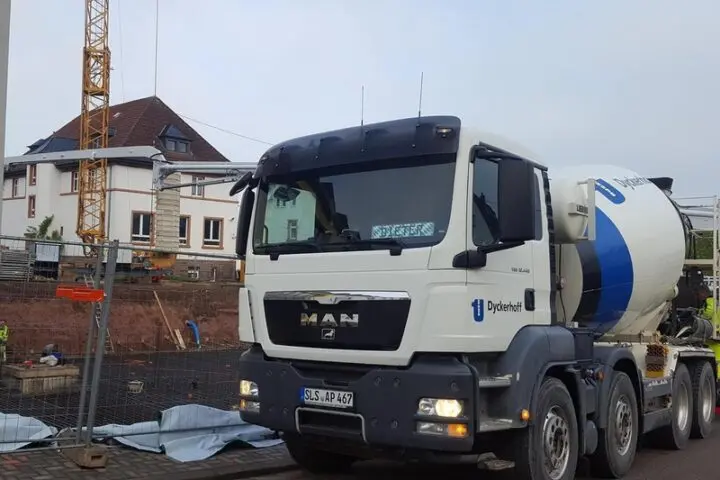 Betonmischer-Lkw an der Baustelle des Erweiterungsbaus, dahinter ein Baukran