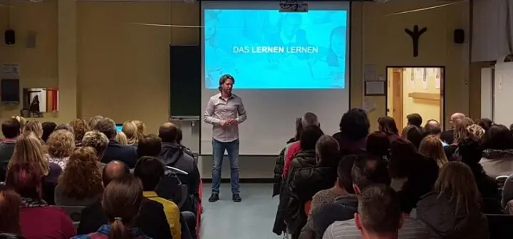 Referent spricht vor vollbesetztem Saal, auf der Leinwand „Das Lernen lernen“