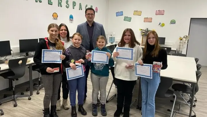 Sechs Schülerinnen mit Urkunden und kleinen Preisen, dahinter zwei Erwachsene, im Makerspace