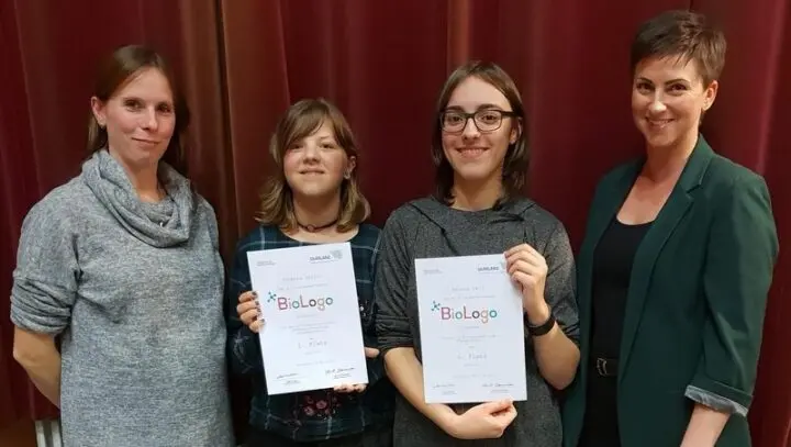 Zwei Schülerinnen mit BioLogo-Urkunden für den 1. und 6. Platz zwischen zwei Frauen